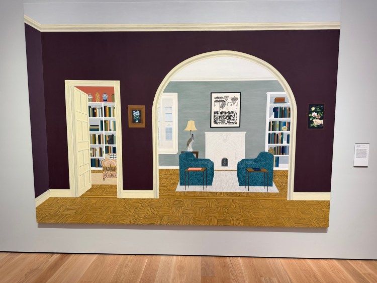 Interior of a house, with love seats facing one another and a lamp with a large bird for a base.